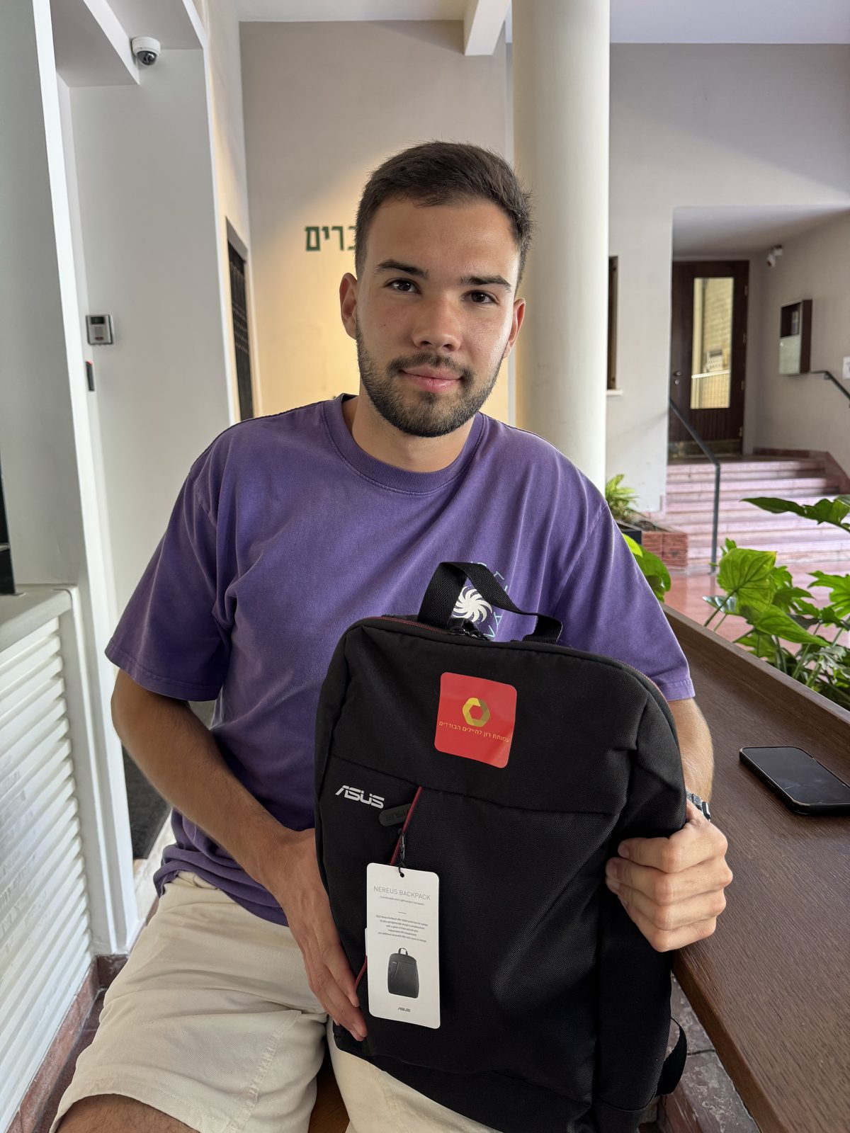 A lone soldier receiving a laptop from the association ahead of starting his studies